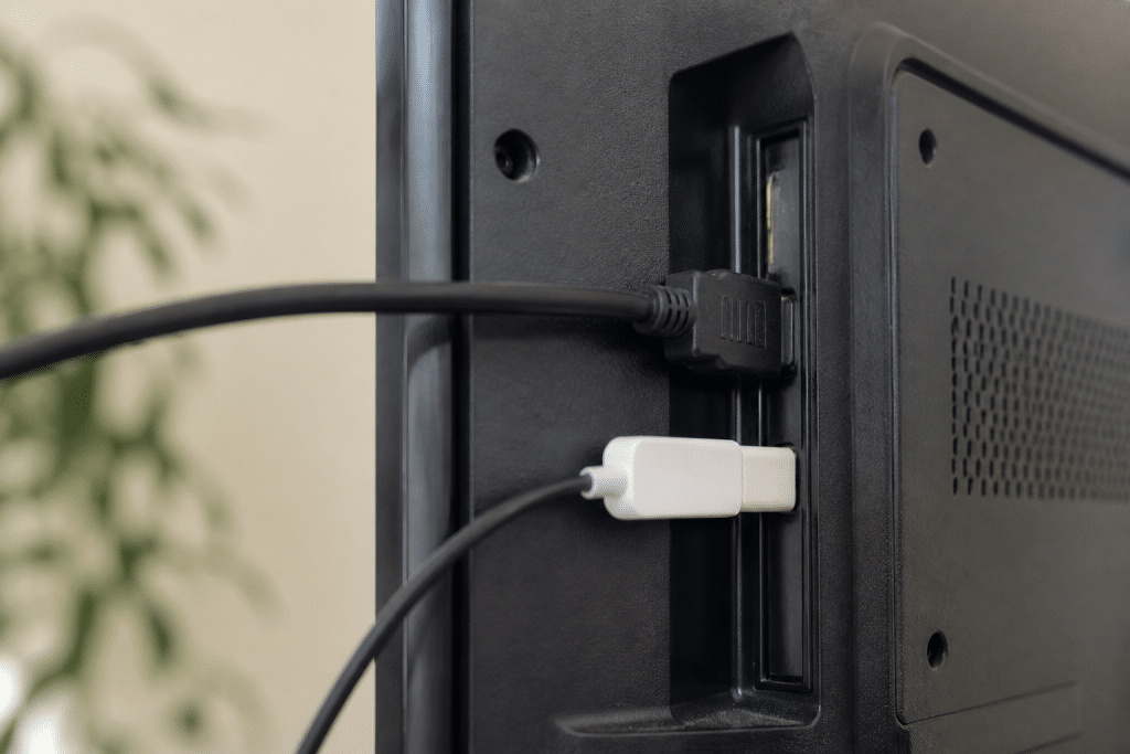 Câble HDMI et adaptateur USB-C connectés à téléviseur noir