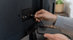 Main tenant cable HDMI entre smartphone et televiseur noir