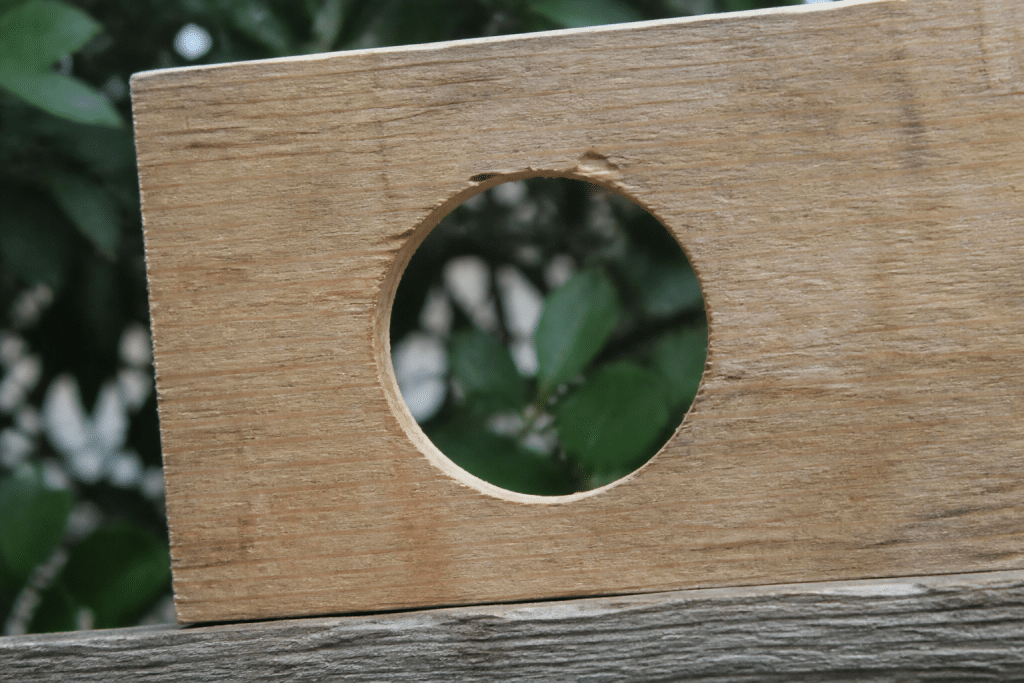 Planche de bois decoupee avec trou d'entree circulaire perce