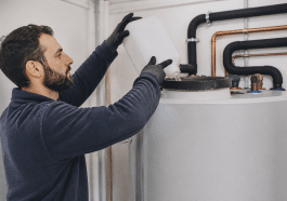 Technicien versant liquide detartrant dans reservoir chauffe eau