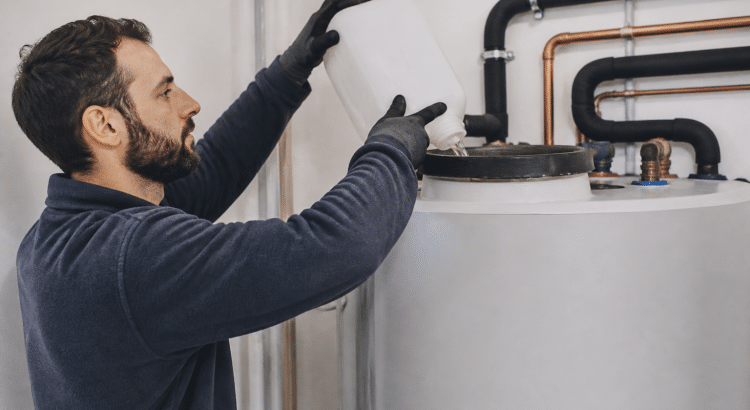 Technicien versant liquide detartrant dans reservoir chauffe eau