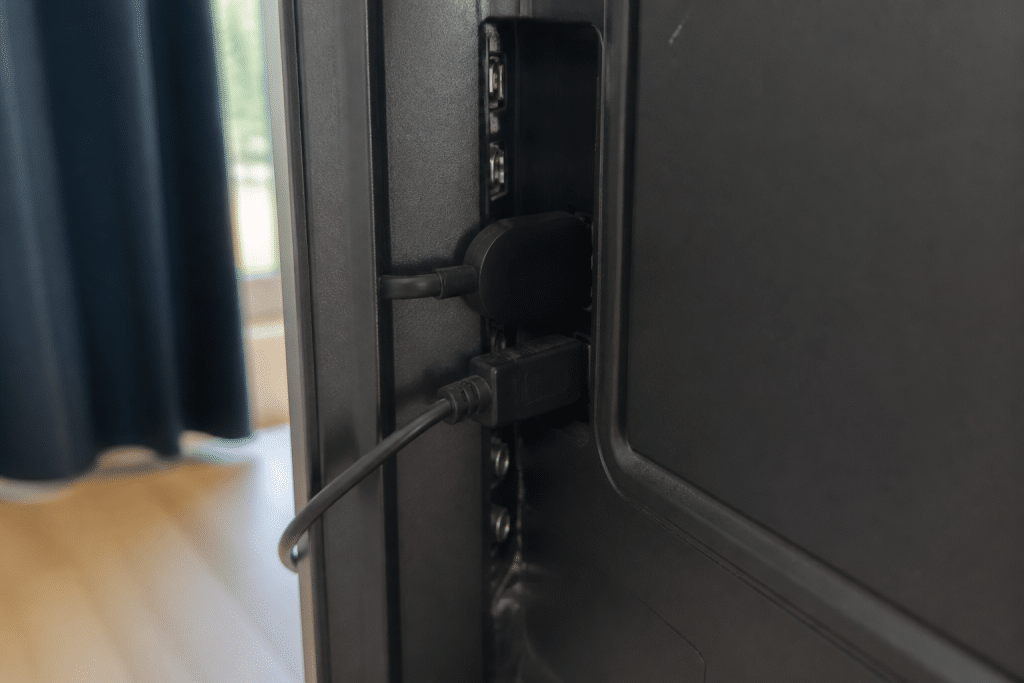 Cable HDMI connecte a televiseur avec dongle streaming noir