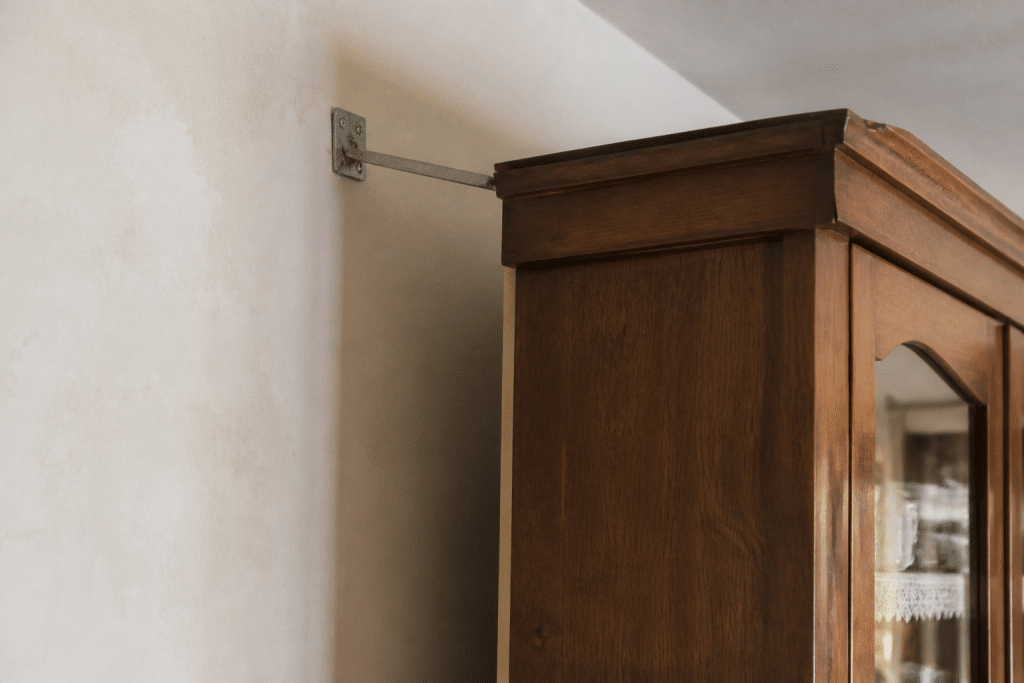 Meuble lourd fixé au mur dans maison sismique