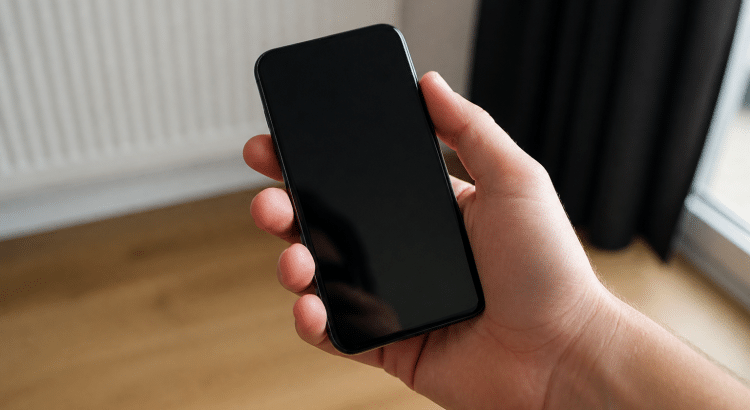 Main tenant telephone noir ecran eteint appareil actif